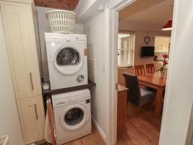 A laundry room with appliances and a dining area at Riverside Cottage in Cockermouth
