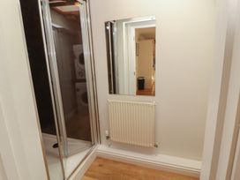 A bathroom with a shower enclosure and mirror at Riverside Cottage in Cockermouth
