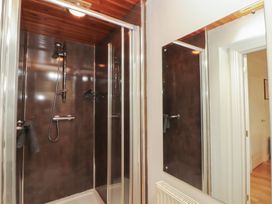 A bathroom with a shower and mirror at Riverside Cottage in Cockermouth