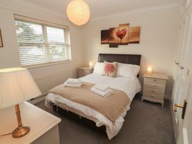 A bedroom with a bed and a nightstand at Riverside Cottage Cockermouth