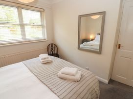 A bedroom with a bed and mirror at Riverside Cottage Cockermouth