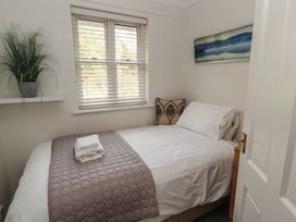 A bedroom with a bed and decorative items at Riverside Cottage in Cockermouth