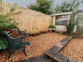 A garden with a bench and gravel at Riverside Cottage in Cockermouth