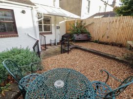 A garden with a table and chairs at Riverside Cottage in Cockermouth