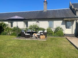 A garden with a table and chairs at Mappowder Cottage near Buckland Newton