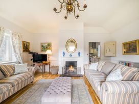 A living room with a fireplace and seating area at Mappowder Cottage in Buckland Newton near Dorchester