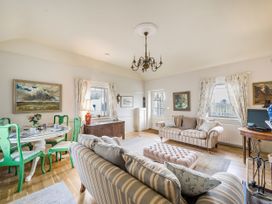 A living room with a sofa and dining area at Mappowder Cottage Buckland Newton near Dorchester