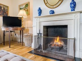 A living room with a fireplace and television at Mappowder Cottage in Buckland Newton near Dorchester