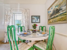 A dining room with a round table and green chairs at Mappowder Cottage Buckland Newton near Dorchester