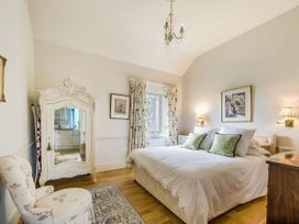 A bedroom with a bed and a mirror at Mappowder Cottage in Buckland Newton near Dorchester
