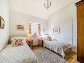 A bedroom with two beds and a window at Mappowder Cottage Buckland Newton near Dorchester