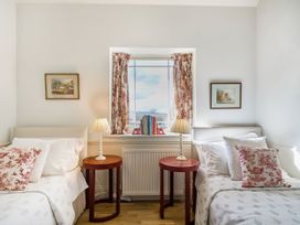 A bedroom with two beds and a window at Mappowder Cottage near Buckland Newton