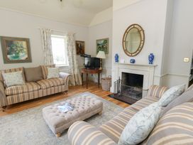 A living room with a fireplace and a couch at Mappowder Cottage in Buckland Newton near Dorchester