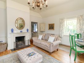 A living room with a sofa and a fireplace at Mappowder Cottage Buckland Newton near Dorchester