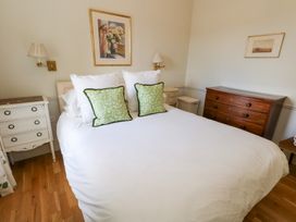 A bedroom with a bed and nightstand at Mappowder Cottage in Buckland Newton near Dorchester