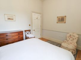 A bedroom with a bed and a chair at Mappowder Cottage in Buckland Newton near Dorchester