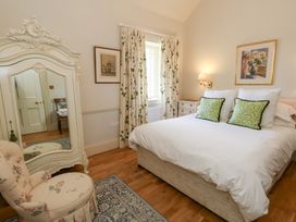 A bedroom with a bed and mirror at Mappowder Cottage in Buckland Newton near Dorchester