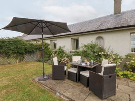 A garden with a table and chairs under an umbrella at Mappowder Cottage Buckland Newton near Dorchester