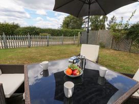 A garden table with coffee mugs and a fruit bowl at Mappowder Cottage in Buckland Newton near Dorchester
