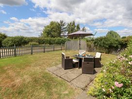 A garden with a seating area and table at Mappowder Cottage near Buckland Newton