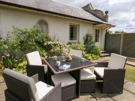A garden with a seating area and flowering plants at Mappowder Cottage Buckland Newton near Dorchester