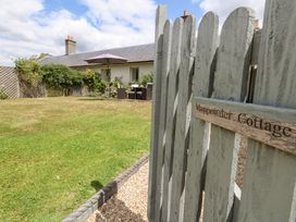 A garden view with a fence and seating area at Mappowder Cottage Buckland Newton near Dorchester
