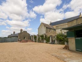 An outdoor area with a gravel surface and buildings at Mappowder Cottage in Buckland Newton near Dorchester