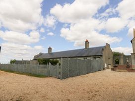 A house with a fence and gravel area at Mappowder Cottage in Buckland Newton near Dorchester