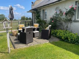 An outdoor seating area with a table and chairs at Maple Cottage in Buckland Newton near Dorchester