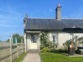 A house with a door and window surrounded by a garden at Maple Cottage in Buckland Newton near Dorchester