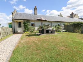A garden with furniture and a parasol at Maple Cottage Buckland Newton near Dorchester