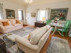 A living room with a sofa and dining table at Maple Cottage in Buckland Newton near Dorchester