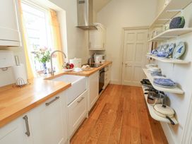A kitchen with a countertop and shelves at Maple Cottage in Buckland Newton near Dorchester