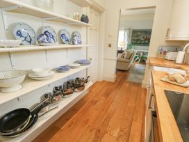 A kitchen with shelves containing dishes and pans at Maple Cottage in Buckland Newton near Dorchester