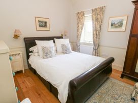 A bedroom with a bed and bedside lamps at Maple Cottage Buckland Newton near Dorchester