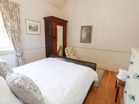 A bedroom with a bed and wardrobe at Maple Cottage Buckland Newton near Dorchester