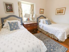 A bedroom with two beds and a window at Maple Cottage Buckland Newton near Dorchester