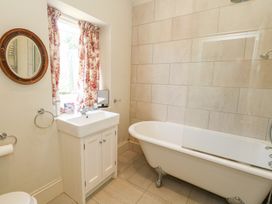 A bathroom with a bathtub and sink at Maple Cottage Buckland Newton near Dorchester