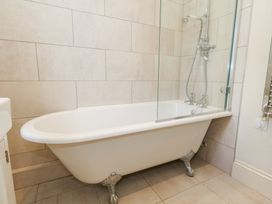 A bathroom with a bathtub and a shower at Maple Cottage Buckland Newton near Dorchester
