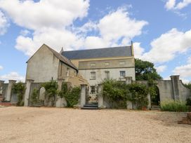 A house with a garden and stone wall at Maple Cottage in Buckland Newton near Dorchester