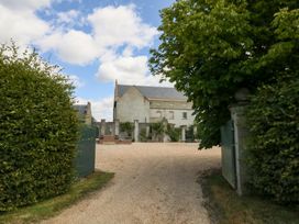 A house with a gravel driveway and greenery at Maple Cottage Buckland Newton near Dorchester