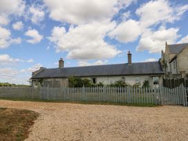A house with a fence and gravel driveway at Maple Cottage in Buckland Newton near Dorchester