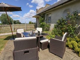 An outdoor dining area with a table and chairs at Maple Cottage Buckland Newton near Dorchester