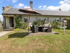 A garden with patio furniture and a parasol at Maple Cottage Buckland Newton near Dorchester