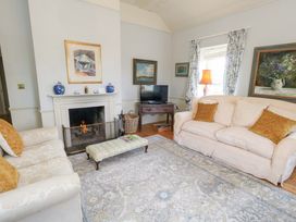 A living room with a fireplace and sofa at Maple Cottage in Buckland Newton near Dorchester