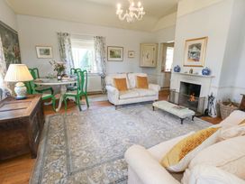 A living room with a sofa and dining area at Maple Cottage in Buckland Newton near Dorchester