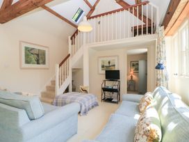 A living room with a sofa and television at Upper Mill Barn, Coln St Aldwyns, near Bibury