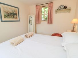 A bedroom with a bed and towels on it at Upper Mill Barn, Coln St Aldwyns, near Bibury