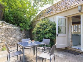 An outdoor area with a table and chairs at Upper Mill Barn, Coln St Aldwyns, near Bibury