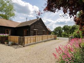A house with a fence and flowers in the garden at Robbie's Barn, Fulready near Stratford-upon-Avon